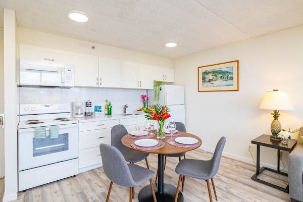 Modern kitchen and dining area with seating for four and bright natural lighting