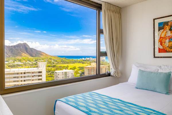 Bedroom with a large window offering views of the mountain and ocean.