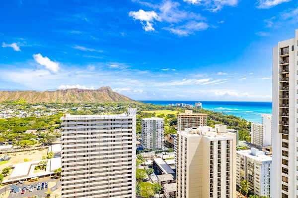 Cityscape view with ocean and mountain backdrop under a clear blue sky