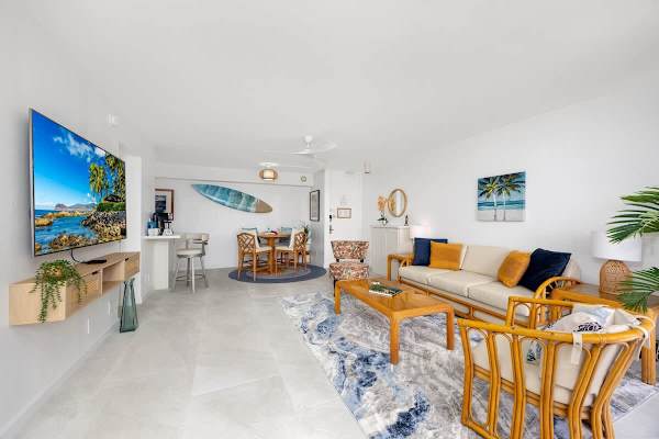 The living room has a pull-out sleeper sofa, coffee table, chairs, and flat-screen TV.