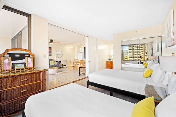 Bedroom with queen- and twin-size beds, a sliding door that separates from the living room, a dresser, and access to the bathroom.
