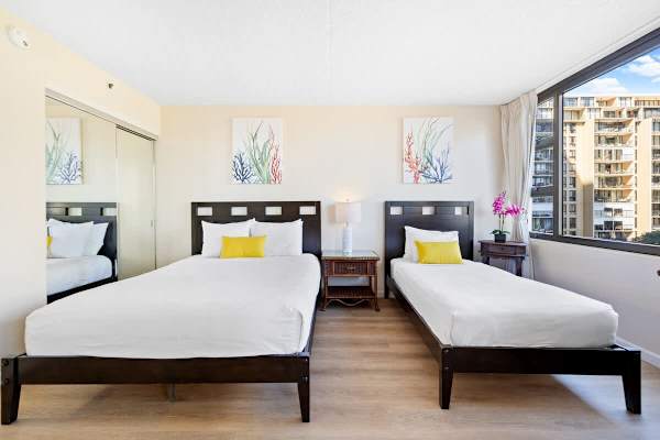 Bedroom with queen- and twin-size beds, a dresser, and a nightstand.