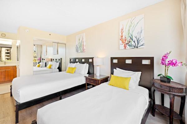 Bedroom with queen- and twin-size beds, a dresser, and a nightstand.