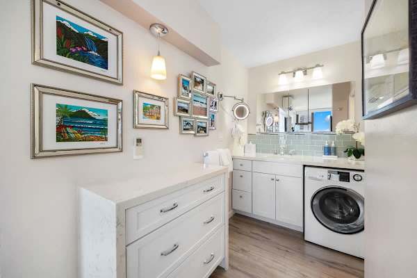 Modern bathroom with a washer and bright wall art for a comfortable stay