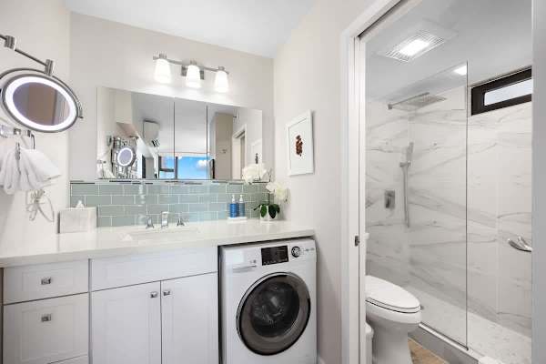Modern bathroom with a glass-enclosed shower and built-in washer for convenience.