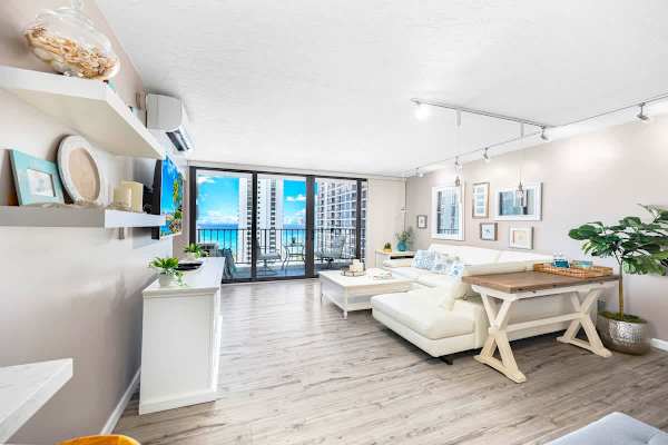Bright living room with modern coastal decor and balcony ocean views