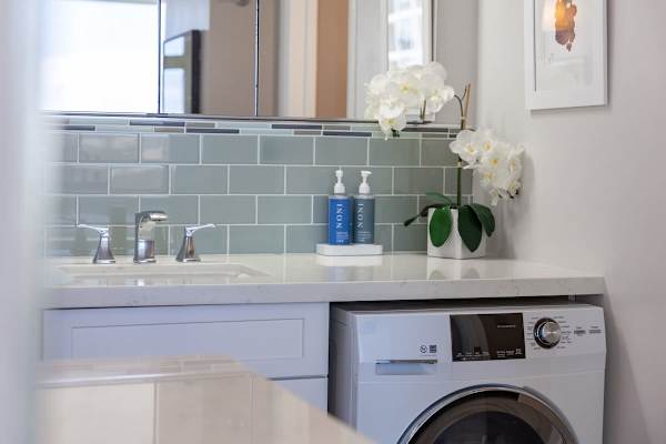 Modern bathroom vanity with built-in washer and green tile backsplash