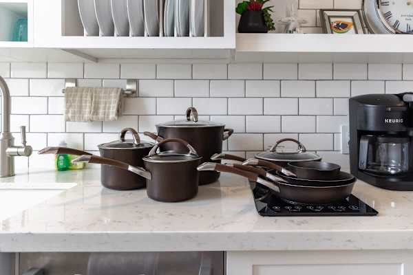 Modern kitchen countertop with a full set of cookware and a coffee maker for convenient meal preparation.