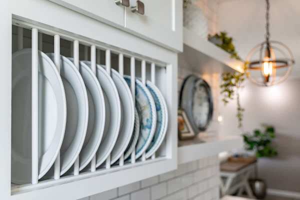 Modern kitchen with organized plate storage and ambient lighting