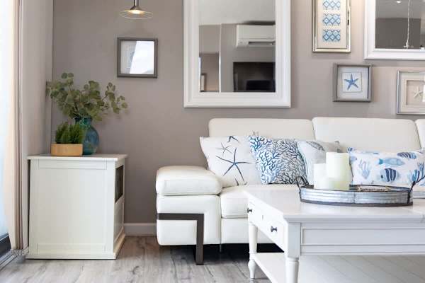Coastal-inspired living room with a white leather sofa and decorative pillows.
