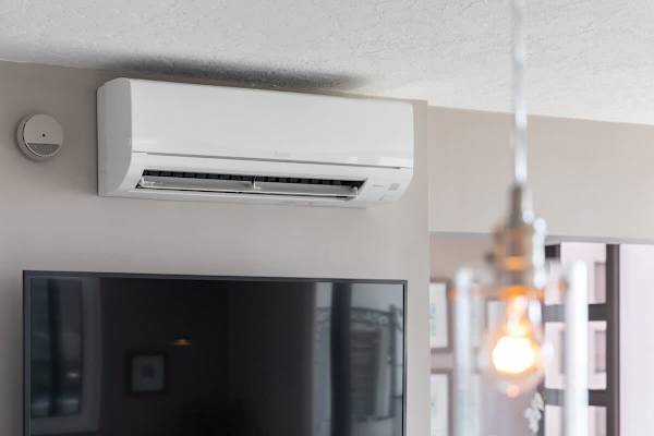 Modern air conditioning unit installed above the television for comfortable living.