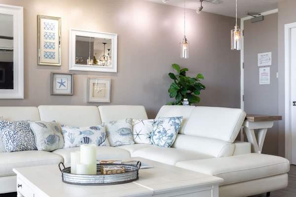 Relax in this modern living room with a white sectional sofa and coastal-themed decor.