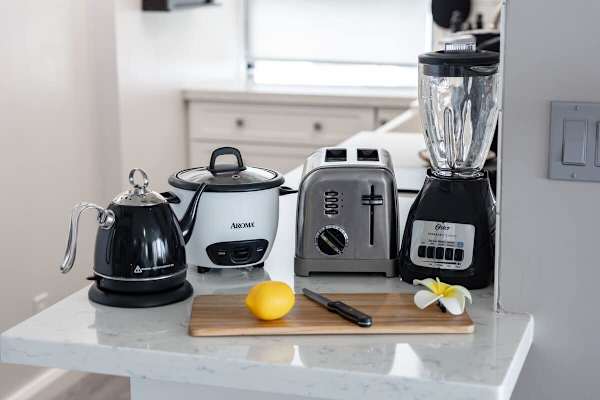 Modern kitchen counter with essential appliances including a toaster, blender, and electric kettle.