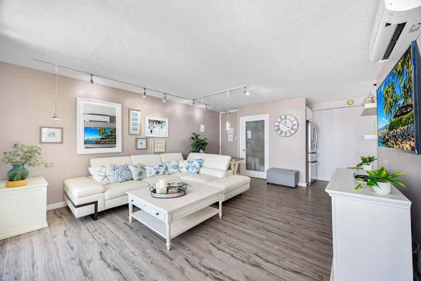 Spacious living room with a modern white sectional sofa and coastal decor accents.