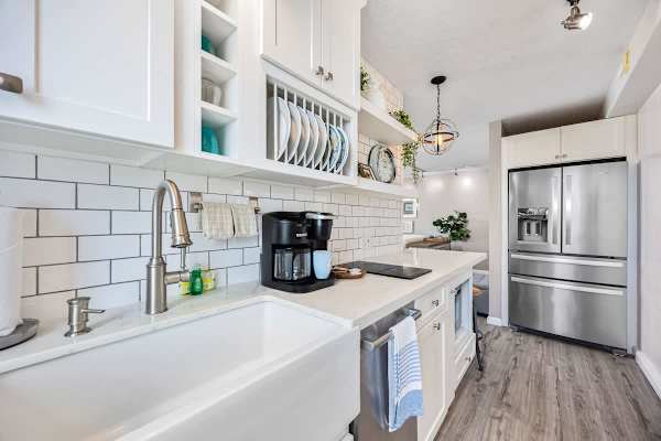 Modern kitchen with farmhouse sink, stainless steel appliances, and open shelving for a bright cooking space.