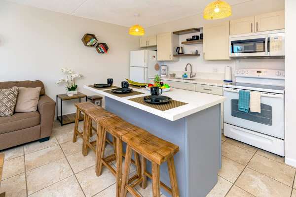 Modern kitchen with a breakfast bar and wooden stools for casual dining.