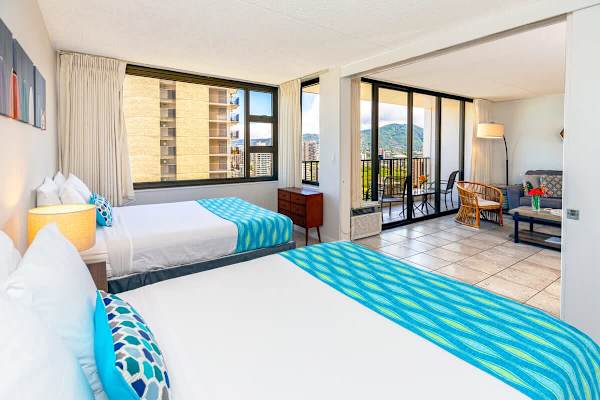 Bright room with two beds and a balcony offering mountain views