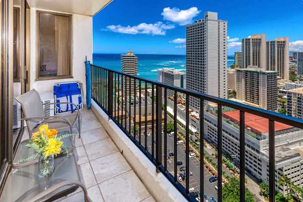 Relax on the balcony with ocean and city views in a high-rise setting.