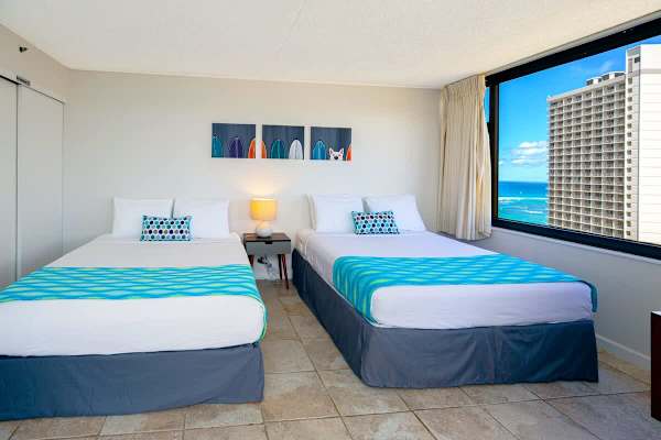 bright room with two beds and ocean views through a large window