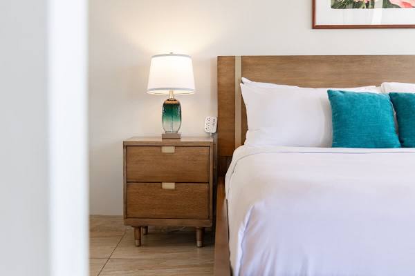 Bright bedroom w/ teal touches & soft linens for a peaceful night's rest.
