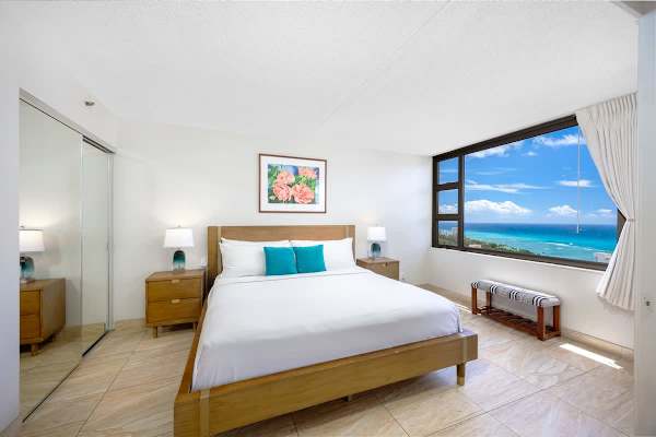 Sun-filled bedroom w/ teal accents & a bed ready to melt your travel fatigue away.
