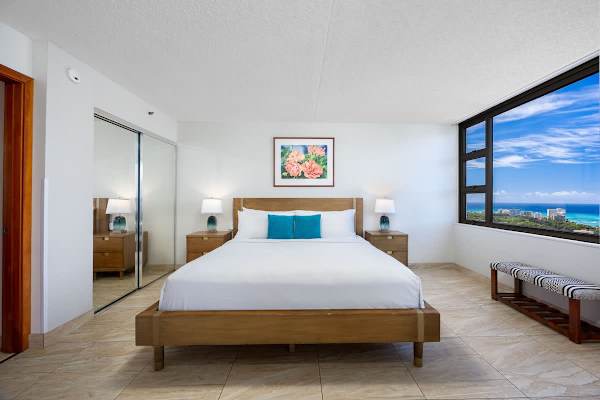 Serene bedroom w/ warm tones & a plush bed to recharge after a day out.

