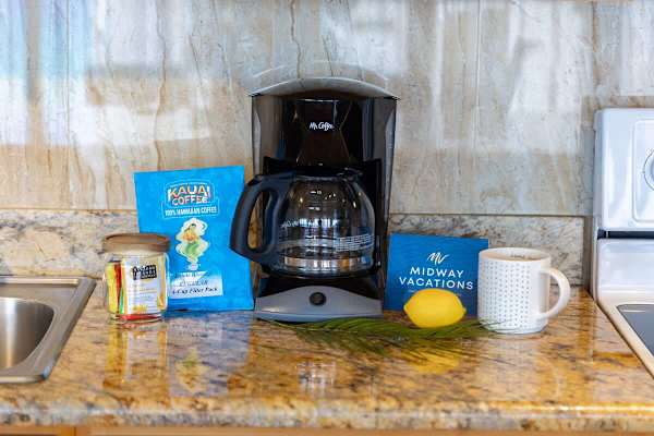 Kitchen counter stocked w/ a coffee maker & essentials to kick off your morning right.
