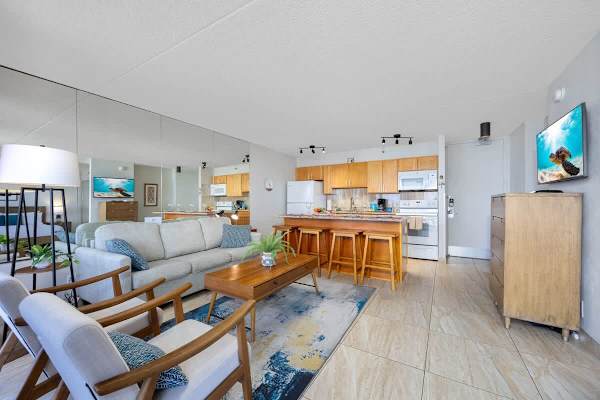 Open-concept living area bathed in natural light w/ sleek, modern furnishings.
