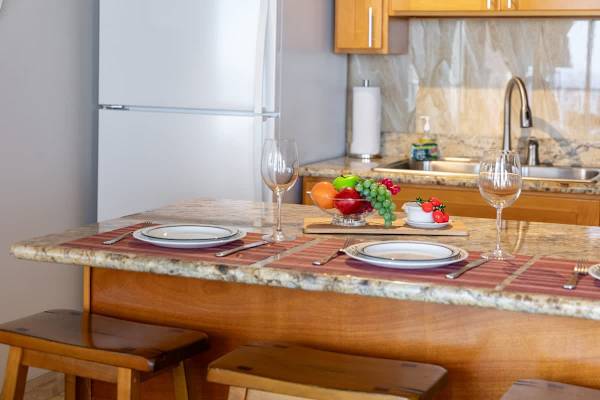 Elegantly set dining table w/ marble-look surfaces & room for a proper sit-down meal.
