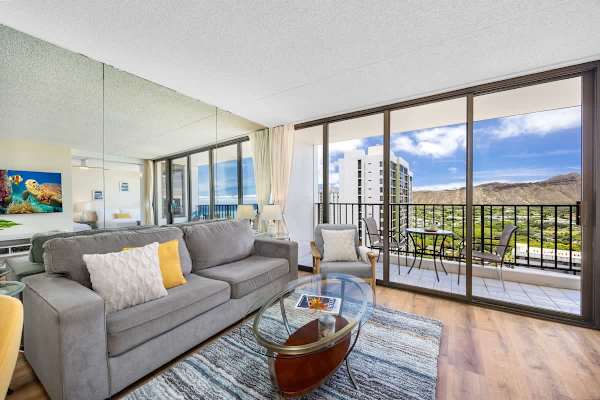 Bright living room with mountain views and access to a balcony seating area.