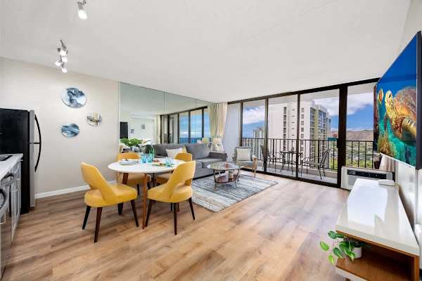 Modern living area with dining space and balcony offering city views
