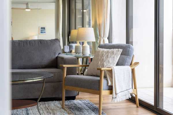 Modern living area with a comfortable armchair and natural light from floor-to-ceiling windows.