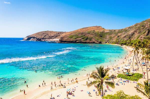 Clear turquoise waters and sandy beach at a popular coastal bay