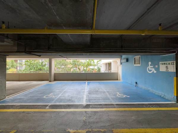 Accessible parking spaces located on the fifth floor of tower ii with natural light and nearby greenery.