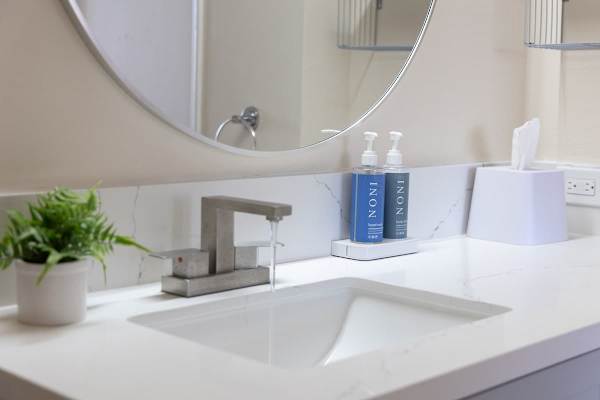 Modern bathroom sink with a sleek faucet and essential toiletries.