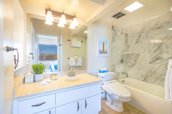 bright bathroom with marble shower walls and modern fixtures