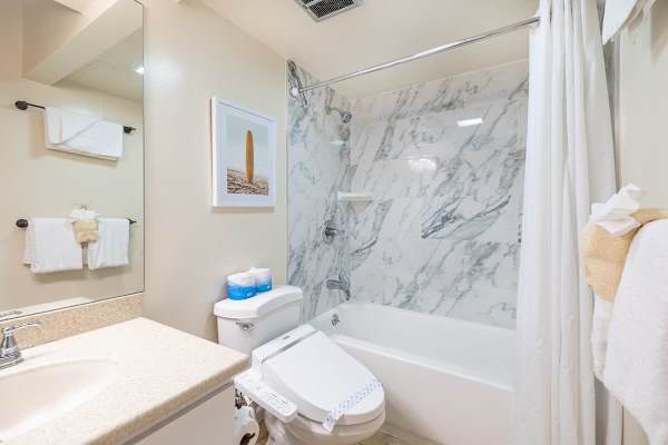 Modern bathroom featuring a marble-tiled shower and a bidet toilet seat for added comfort.