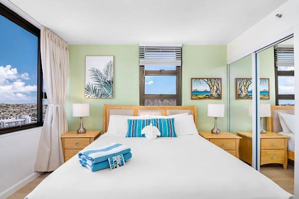 Bright bedroom with city views and natural wood furnishings