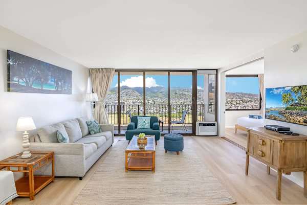 Bright living room with mountain views and access to a balcony seating area.