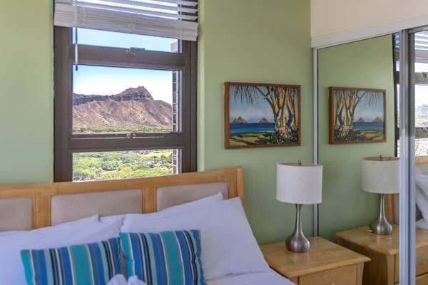 bedroom with a view of diamond head and a coastal painting on the wall