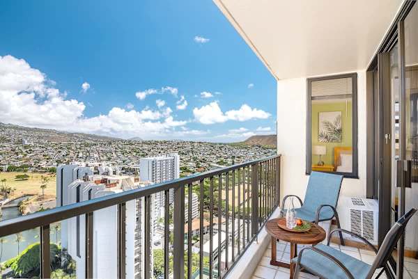Relax on the balcony with city and mountain views in this modern high-rise apartment.