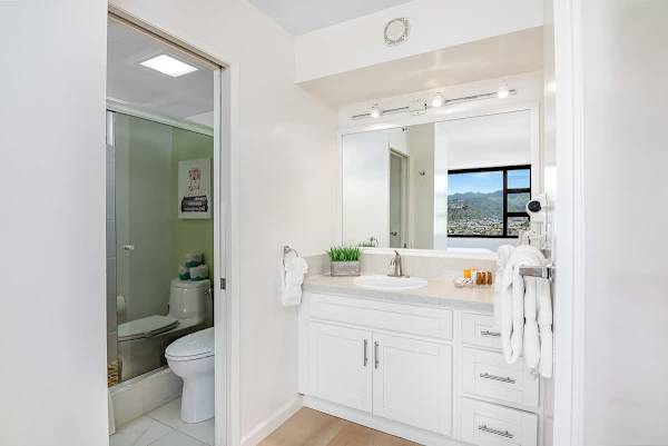 Bright bathroom with a large mirror and a view of the mountains through the window.