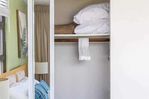 Closet space with hangers and extra bedding for guest convenience