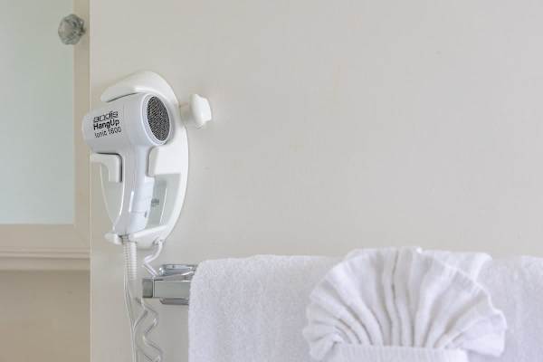 Wall-mounted hairdryer and neatly folded towel in the bathroom