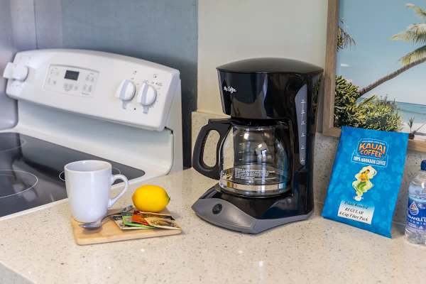 Kitchen countertop with a coffee maker, Hawaiian coffee, and tea setup for a relaxing start.