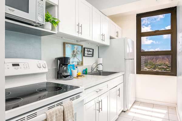 Bright kitchen with white cabinetry and a view of the mountains through the window