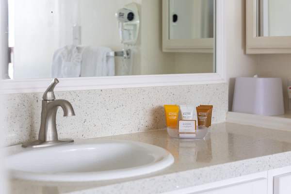Bathroom countertop with essential toiletries and a modern faucet.