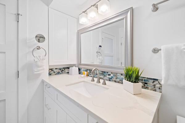 The bathroom has a vanity with a cabinet!