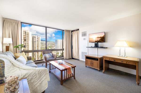 Living room with mountain and city views, dining area, desk, and pull-out sleeper sofa
