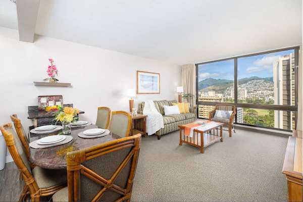 Living room with mountain and city views, dining area, desk, and pull-out sleeper sofa, flat screen TV